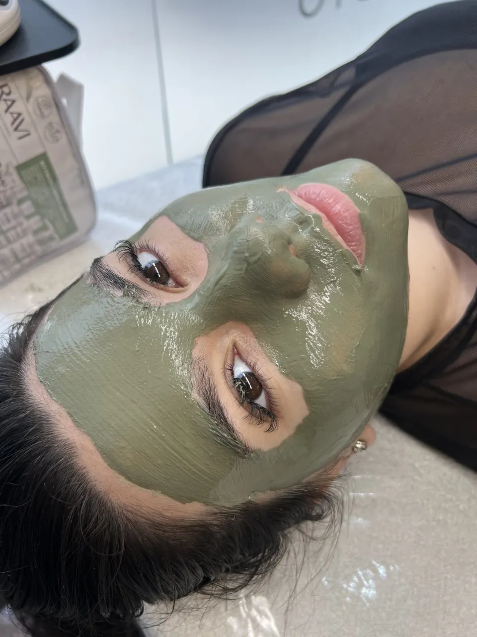 Cliente com máscara facial de argila durante o atendimento