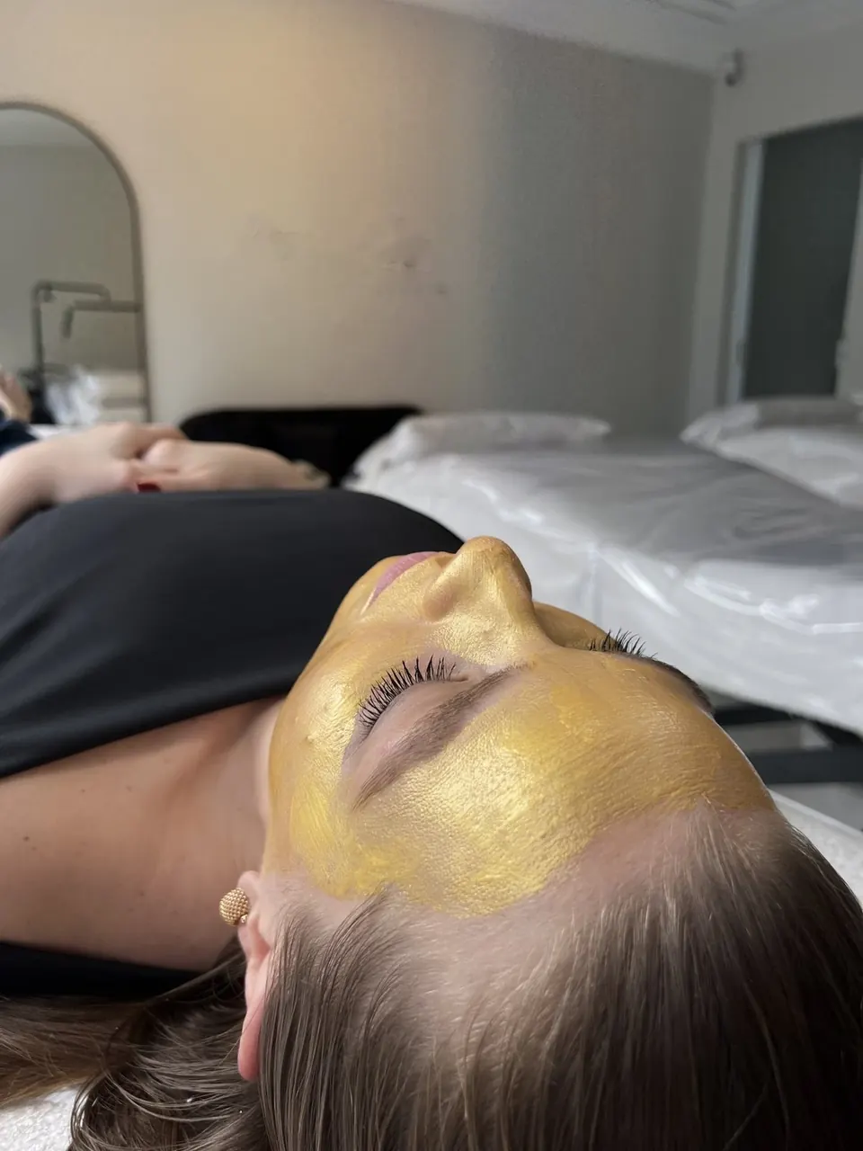 Cliente com máscara facial dourada durante o atendimento